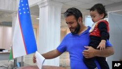 A voter in Uzbekistan casts a ballot in a referendum on a revised constitution, Tashkent, Uzbekistan, April 30, 2023. 