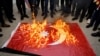 Sejumlah demonstran di Mosul, Iraq, membakar bendera Turki dalam aksi protes terhadap serangan Turki ke wilayah Dohuk, Irak, pada 21 Juli 2022. (Foto: Reuters/Khalid Al-Mousily)