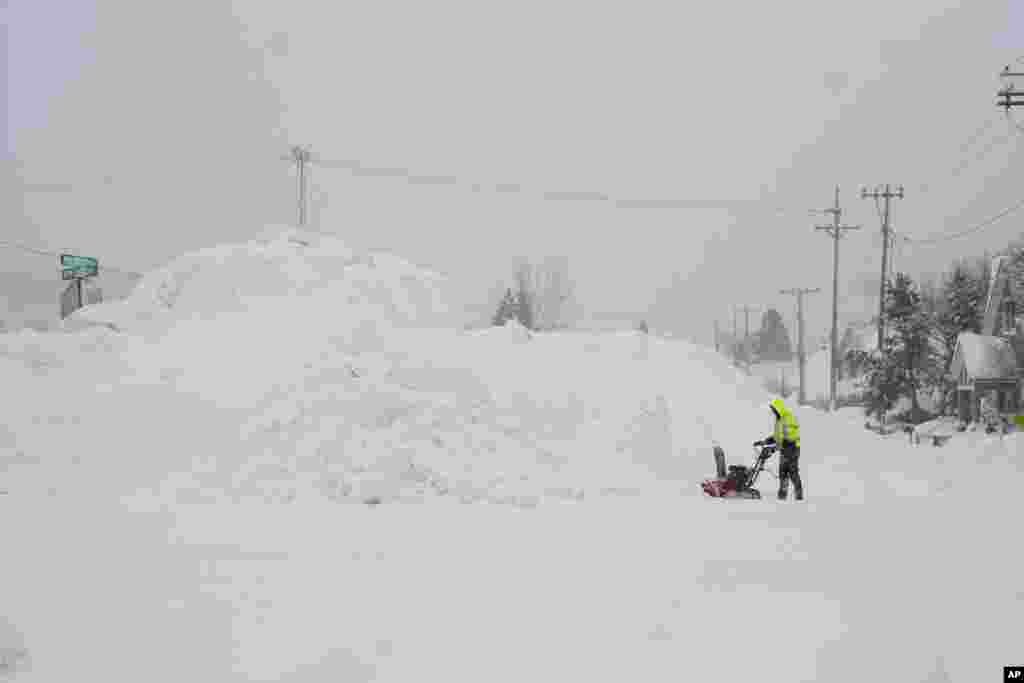 Un hombre usa una sopladora de nieve mientras la nieve se acumula durante la tormenta, en Truckee, California. 