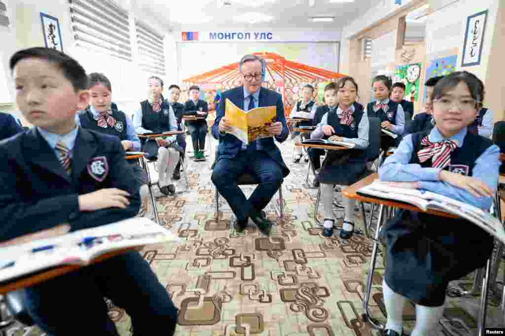 British Foreign Secretary David Cameron meets pupils and takes part in an English lesson at School No.23, during his tour of the Central Asia region, in Ulaanbaatar, Mongolia.