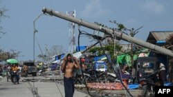 ဆိုင်ကလုန်းမုန်တိုင်း မိုခါဝင်ရောက်တိုက်ခတ်အပြီး စစ်တွေမြို့ပေါ်မှာ လဲကျသွားတဲ့ ဓါတ်တိုင်နဲ့ လမ်းသွားလမ်းလာတဦးကိုတွေ့ရစဉ် (မေ ၁၇၊ ၂၀၂၃)