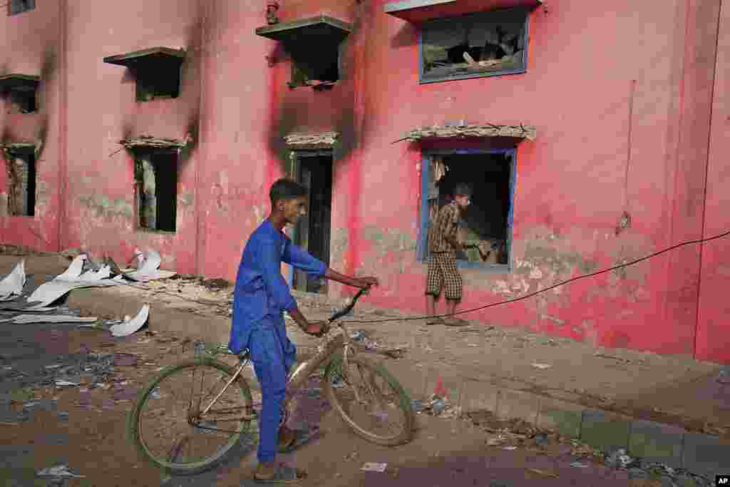 Youngsters look at a church vandalized by an angry Muslim mob in Pakistan on Aug. 17, 2023.