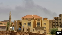 FILE - Smoke rises above buildings in Khartoum on May 12, 2023, as fighting between the forces of two rival generals continues. 