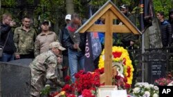 People stand at the grave of Russian mercenary chief Yevgeny Prigozhin who died in a plane crash, marking 40 days from the date of his death, at the Porokhovskoye cemetery in St. Petersburg, Russia, Oct. 1, 2023.
