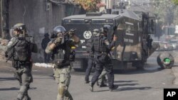 Yon manm fos sekirite Izraelyen an pwente zam li pandan yon lese frape ak Palestinyen yo nan es Jeruzalem, Vandredi 13 Oktob, 2023.