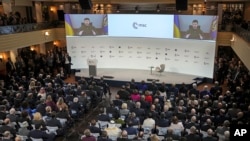 President Volodymyr Zelenskyy of Ukraine speaks from a screen at the Munich Security Conference in Munich, Germany, Feb. 17, 2023. 