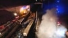 Smoke rises from trains as firefighters and rescuers operate after a collision near Larissa city, Greece, early March 1, 2023. 
