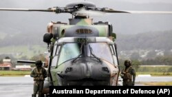 澳洲皇家海軍飛行員站在一架MRH90太攀蛇（Taipan）直升機旁。 （2021年11月27日）