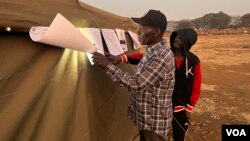 Some voted during the night as voting was extended to a second day Aug. 24, 2023, in Harare, Zimbabwe, after election day was marred by polling station delays and shortages of ballots in opposition strongholds Bulawayo and Harare. (Columbus Mavhunga/VOA)