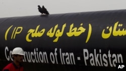 FILE - An Iranian worker walks past the Pakistan-Iran Gas Pipeline Project in Gabd near Pakistani border in Iran, March 11, 2013. 