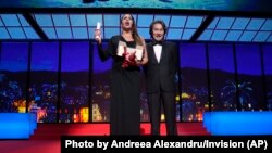 Karla Sofia Gascon, left, holds the award for best actress for 'Emilia Perez,' alongside Koji Yakusho, during the 77th international film festival, Cannes, France, May 25, 2024.