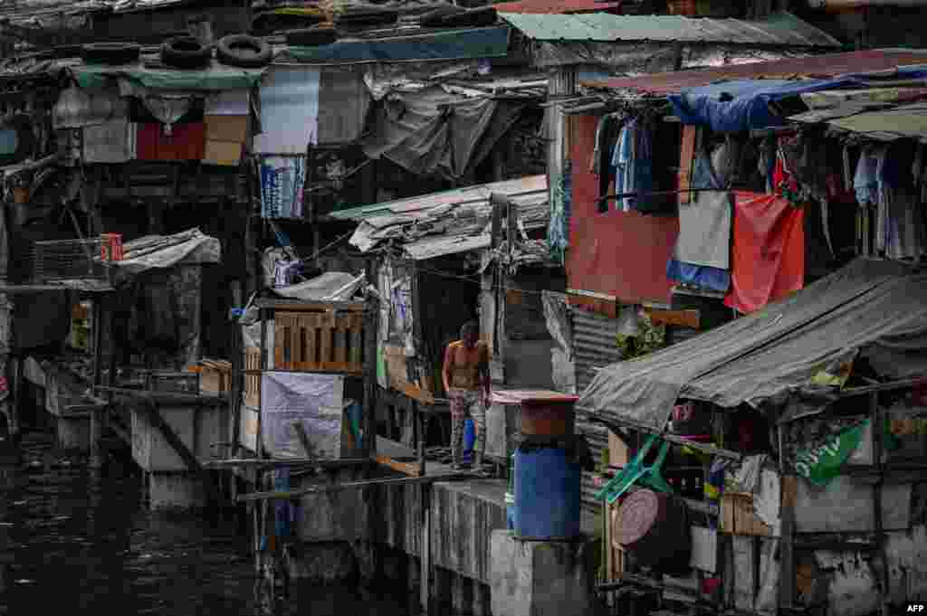 A man walks along makeshift homes in Manila, Philippines.