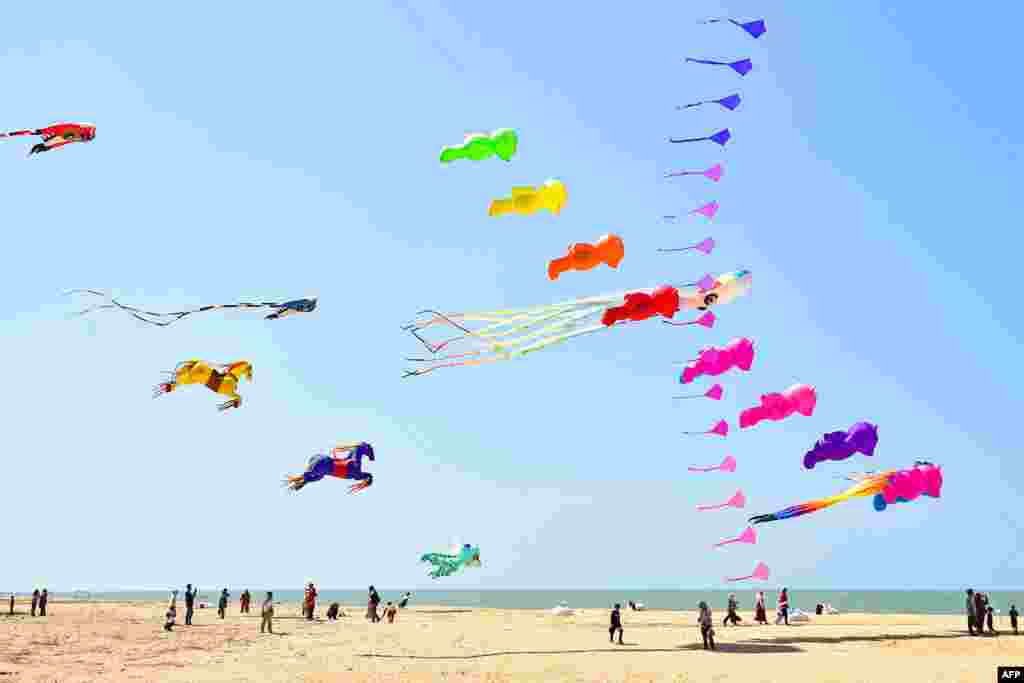 People gather during a kite festival on Ao Manao Beach in the southern Thai province of Narathiwat.