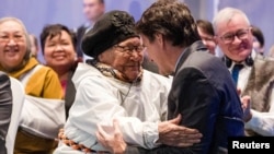 Canada’s Prime Minister Justin Trudeau, right, is greeted by an elder during a devolution ceremony at the Aqsarniit Hotel & Conference Centre in Iqaluit, Nunavut, Canada, Jan. 18, 2024.
