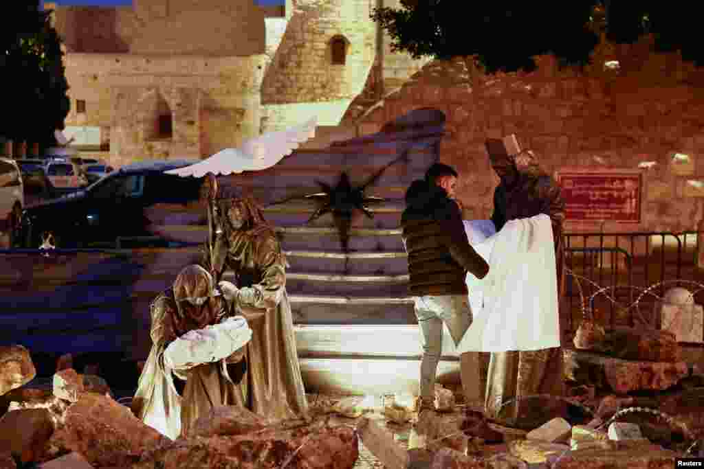 En Belén, la Navidad tuvo una cara completamente diferente. En medio de escombros y rodeados por un alambre de púas, se ve el pesebre afuera de la Iglesia de la Natividad. 