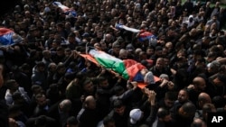 Palestinians carry the ones that where killed after an Israeli military raid on Nur Shams refugee camp in the West Bank, Dec. 27, 2023.