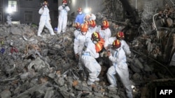 2022年5月5日救援人員從長沙市一棟倒塌的六層建築中抬出一名生還者。
