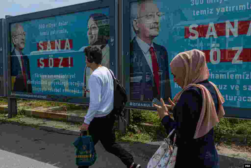 People pass by one of the many campaign billboards that can be seen all over Istanbul, on May 8, 2023. (Yan Boechat/VOA)