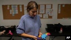 Andrea Cukerman, ingeniera eléctrica y fundadora de Manos de Héroes, explica cómo funcionan sus manos protésicas en la sede de la fundación en el centro de Montevideo, Uruguay, el viernes 14 de abril de 2023. (Foto AP/Matilde Campodónico)