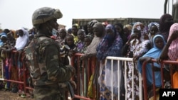Un soldat de l'armée nigérienne monte la garde, alors que des partisans attendent l'arrivée du président nigérien Mohamed Bazoum, à Sara-Koira dans l'ouest du pays, le 11 septembre 2021