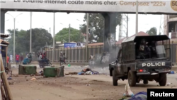 Capture d'écran d'une vidéo d'un manifestant antigouvernemental lançant un objet sur la police à Conakry, Guinée, le 10 mai 2023.