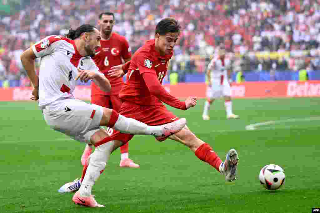 Georgia's midfielder #06 Giorgi Kochorashvili (L) fights for the ball with Turkey's forward #19 Kenan Yildiz during the UEFA Euro 2024 Group F football match between Turkey and Georgia at the BVB Stadion in Dortmund, Germany.