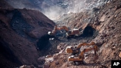 In this photo released by China's Xinhua News Agency, rescuers work at the site of a collapsed open pit coal mine in Alxa League in northern China's Inner Mongolia Autonomous Region, Feb. 23, 2023. 