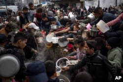 Warga Palestina mengantre makan di Rafah, Jalur Gaza, 21 Desember 2023. (Foto: AFP)