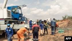 Waokoaji wakiwa kazini kuwaokoa wachimbaji wapatao 40 wa dhahabu waliokwama ndani ya shimo lililoporomoka katika mgodi wa Ran huko Bindura Zimbabwe, tarehe 26, Novemba 2020. Picha na Jekesai NJIKIZANA / AFP. 