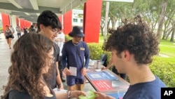 Sejumlah mahasiswa membagikan selebaran yang berisi informasi terkait pemilu bagi para pemilih muda di Florida Atlantic University, di Boca Raton, Florida, pada 11 April 2024. (Foto: AP/Cody Jackson)