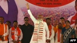 India's Prime Minister Narendra Modi (C) greets supporters of the Bharatiya Janata Party (BJP) during his election campaign rally in Prayagraj, northern India, on May 21, 2024. 