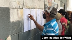 ARCHIVO - Un ciudadano ubica la mesa en la que le corresponde votar en las elecciones regionales y municipales celebradas en Venezuela en 2021.