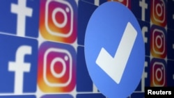Ilustrasi - Lencana verifikasi berwarna biru, logo Facebook dan Instagram, 19 Januari 2023. (REUTERS/Dado Ruvic)