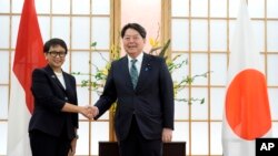 Menlu RI Retno Marsudi (kiri) dan Menlu Jepang, Yoshimasa Hayashi, berjabat tangan menjelang pertemuan mereka di Tokyo, Senin, 6 Maret 2023. (AP/Eugene Hoshiko)