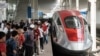 Masyarakat berfoto dengan gerbong pertama Kereta Cepat Jakarta-Bandung (KCJB) saat tahap uji coba umum selama seminggu di Stasiun Tegalluar, Bandung, Jawa Barat, 17 September 2023. (Yasuyoshi CHIBA / AFP)