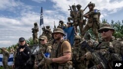 Combatientes del Cuerpo de Voluntarios Rusos se preparan para la conferencia de prensa no lejos de la frontera en la región de Sumy, Ucrania, el miércoles 24 de mayo de 2023.