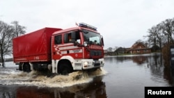 Firefighters of the city of Bremen drive through flooded streets following heavy rainfalls in Lilienthal near Bremen, northern Germany, Dec. 28, 2023. 