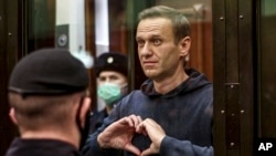 ARCHIVO: El opositor ruso Alexei Navalny hace un gesto con las manos durante una audiencia en una corte e Moscú el 3 de febrero de 2021.