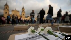 Flores se encuentran en cajas que representan ataúdes simbólicos durante un evento que recuerda a exguerrilleros y líderes sociales que han sido asesinados desde la firma en 2016 de un acuerdo de paz entre las FARC y el gobierno, en Bogotá, Colombia, el 20 de febrero de 2024.