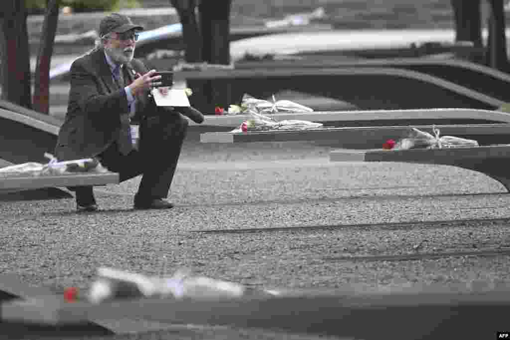 A man takes a photograph at the National 9/11 Pentagon Memorial on the 22nd anniversary of the September 11, 2001 terrorist attack, in Washington.