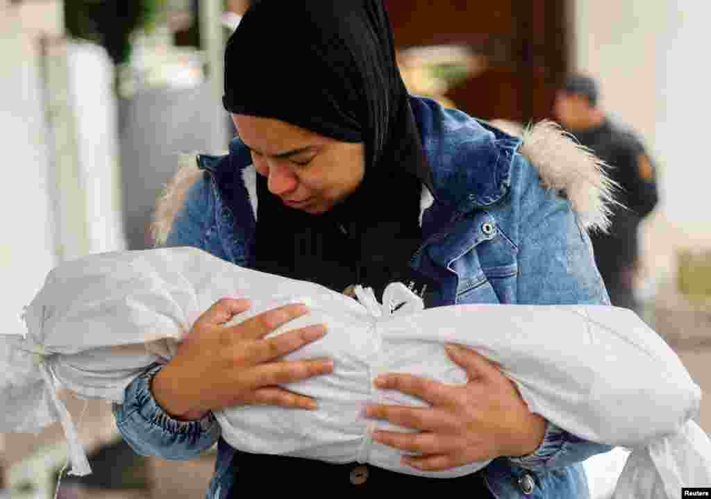 A woman cries while holding the body of a Palestinian child killed in an Israeli strike, amid the ongoing conflict between Israel and the Palestinian Islamist group Hamas, at Abu Yousef al-Najjar hospital in Rafah, in the southern Gaza Strip.