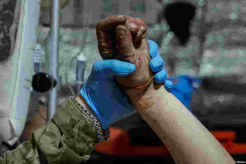 Un médico sostiene la mano de un soldado herido tras los últimos combates de las fuerzas ucranianas contra el avance de Rusia en el este de Ucrania, cerca de la ciudad de Chasiv Yar, en la región de Donetsk, el 1 de julio de 2024. 