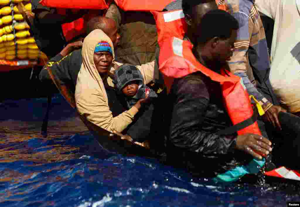 A migrant holds her baby on a small iron boat during a rescue by the Geo Barents migrant rescue ship, operated by Medecins Sans Frontieres (Doctors Without Borders), in international waters between Tunisia and Lampedusa, in the central Mediterranean Sea, July 20, 2024. 