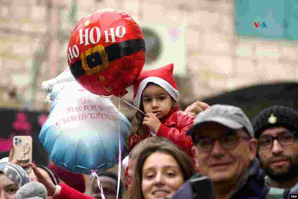 Una niña vestida con motivos navideños observa el desfile de Navidad celebrado el pasado año 2022, en la ciudad de Belén. Este año, la tierra donde nació Jesús ha suspendido todos los festejos en solidaridad con las víctimas de la guerra en Gaza. 