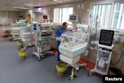 Seorang pekerja medis membantu bayi prematur Palestina yang terbaring di inkubator di bangsal bersalin Rumah Sakit Shifa, Kota Gaza, 22 Oktober 2023. (Foto: Reuters)
