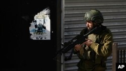 FILE - An Israeli soldier is seen during an army operation in the Jenin refugee camp in the West Bank, Dec. 12, 2023. The Israeli military has rounded up hundreds of people across the Gaza Strip since the Hamas militant group attacked Israel on Oct. 7, 2023.