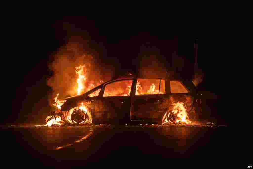 A car is on fire on Riviere Salee's main road in Noumea, in the French Pacific territory of New Caledonia. A fresh surge of unrest hit the territory, with several buildings set on fire overnight, including a police station and a town hall, authorities said.