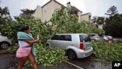 Una residente registra los daños a los automóviles afuera de un complejo de apartamentos en Tallahassee, Florida, el viernes 10 de mayo de 2024.