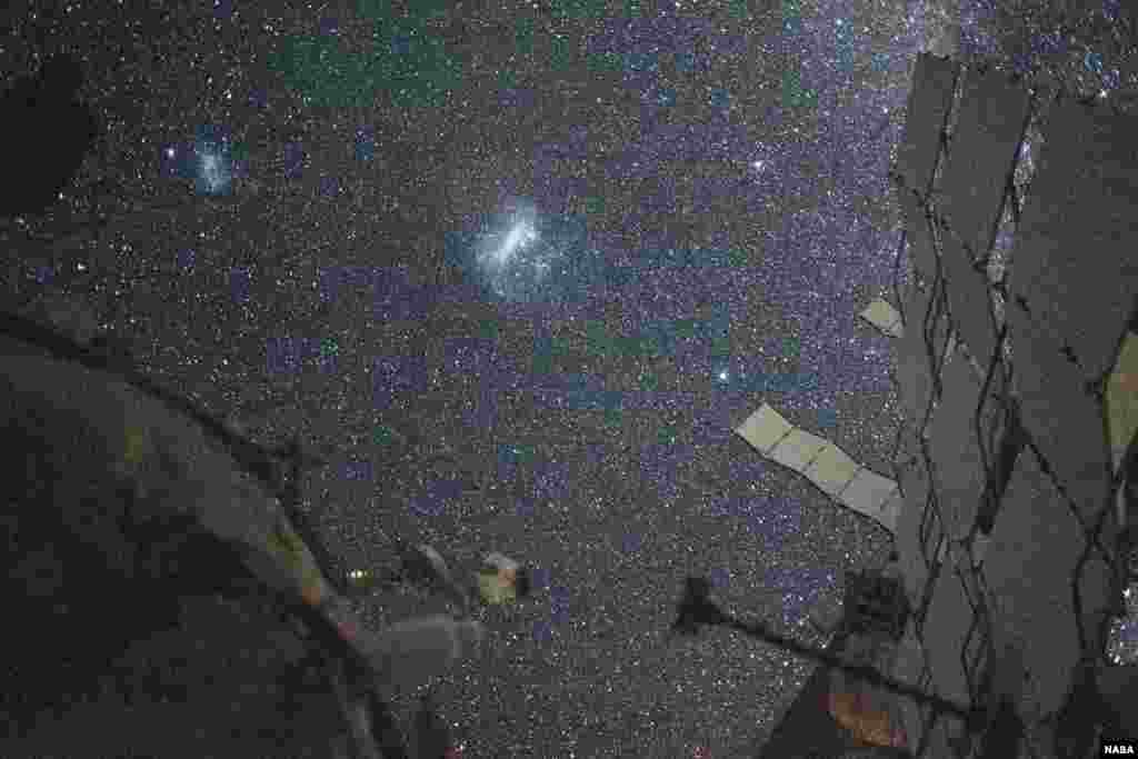 The Large Magellanic Cloud (center) and the Small Magellanic Cloud (upper left), dwarf galaxies in close proximity with the Milky Way galaxy, are pictured from the International Space Station, Aug. 6, 2024. NASA astronaut and Expedition 71 Flight Engineer Matthew Dominick took this long-duration photograph with a station camera increasing its sensitivity to account for low light conditions.
