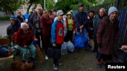 Vovchansk area residents, who fled due to Russian military strikes, gather at an evacuation point, amid Russian attacks, in Ukraine's Kharkiv region, May 14, 2024.